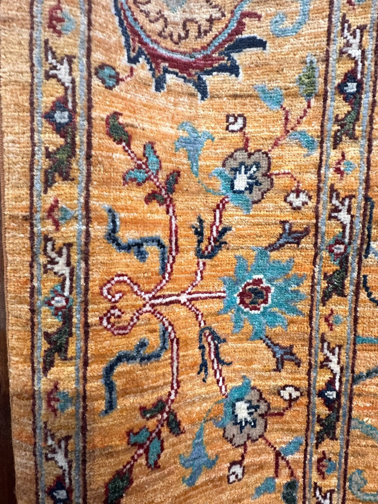 Detail of turquoise flowers, burgundy scrolling vines and decorative Sultani border